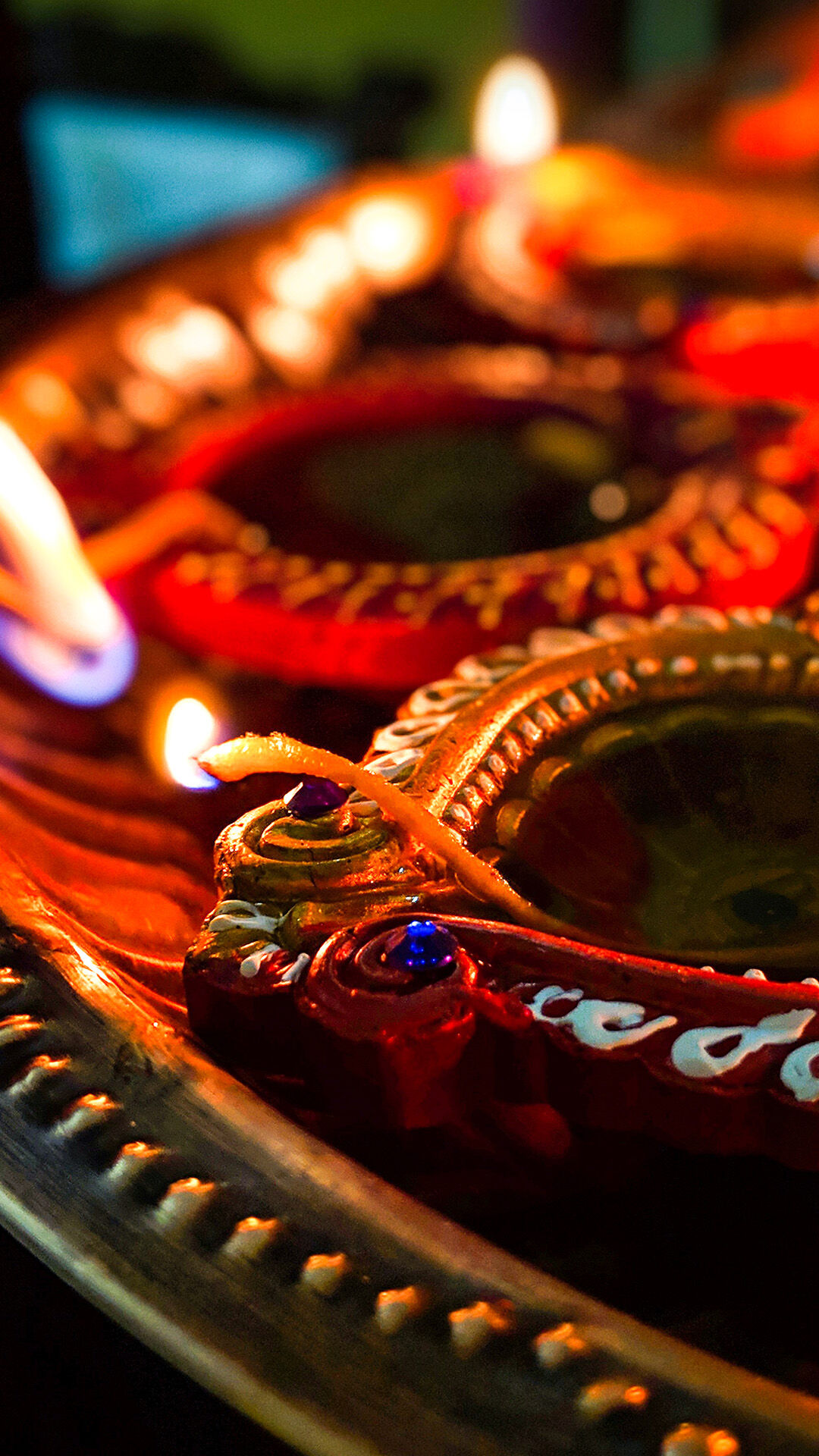 A close-up of traditional clay diyas glowing with light on a festive tray for Diwali.